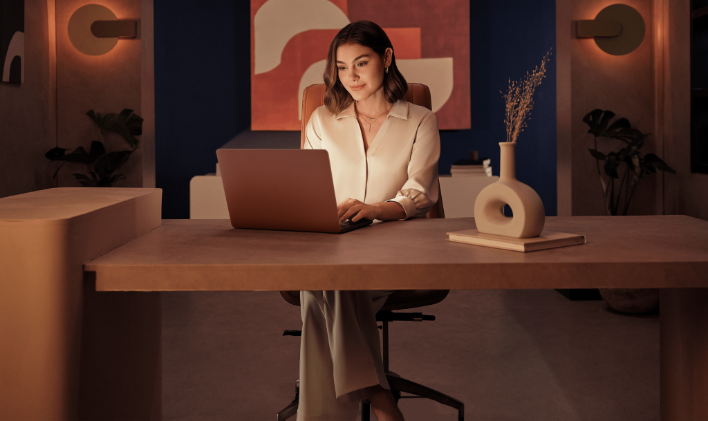Woman working comfortably at a laptop wearing Alcon TOTAL contact lenses